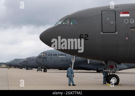 Mitarbeiter der Republic of Singapore Air Force führen vor dem Flug Kontrollen an einem RSAF A330 Multi-Role-Tanker durch Transportflugzeug neben einer Reihe von Frachtflugzeugen der US Air Force auf der Fluglinie des Luftwaffenstützpunkts Spangdahlem, Deutschland, 29. August 2021. Vom 27. Bis 30. August haben sich der 52. Kampfflügel und das 726. Flugmobilitäts-Geschwader mit dem Personal der Streitkräfte Singapurs zusammengetan, um Evakuierungsoperationen in Afghanistan zu unterstützen. Stockfoto