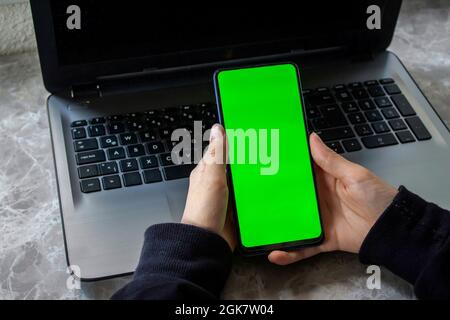 Frau Hand hält grünen Bildschirm Handy. Stockfoto