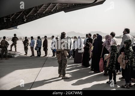 Evakuierte warten während einer Evakuierung auf dem Hamid Karzai International Airport, Kabul, Afghanistan, am 30. August auf den Einsteigen in eine Boeing C-17 Globemaster III. US-Dienstmitglieder unterstützen das Außenministerium bei einer nicht-kämpferischen Evakuierungsoperation (NEO) in Afghanistan. Stockfoto