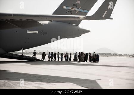 Evakuierte warten während einer Evakuierung auf dem Hamid Karzai International Airport, Kabul, Afghanistan, am 30. August auf den Einsteigen in eine Boeing C-17 Globemaster III. US-Dienstmitglieder unterstützen das Außenministerium bei einer nicht-kämpferischen Evakuierungsoperation (NEO) in Afghanistan. Stockfoto