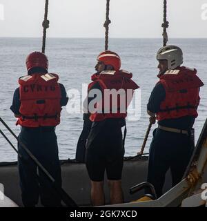 210831-N-NY362-2015 ARABIAN SEA (AUG 31, 2021) – von links, Boatswain's Mate 3rd Class Corey Delacruz, Master-at-Arms 3rd Class Maximilian Young und LT. j.g. Miguel Acosta bereitet sich auf die Durchführung von Kleinbootoperationen an Bord des Flugzeugträgers USS Ronald Reagan (CVN 76) in der Arabischen See vor, August 31. Ronald Reagan ist das Flaggschiff der Carrier Strike Group 5 und wird im Einsatzgebiet der 5. US-Flotte eingesetzt, um die maritime Stabilität und Sicherheit in der Zentralregion zu gewährleisten, die das Mittelmeer und die verbindet Stockfoto