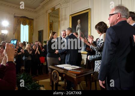 First Lady Michelle Obama begrüßt Susan Selke, die Mutter von Clay Hunt, als Präsident Barack Obama applaudiert, nachdem er am 12. Februar 2015 im East Room des Weißen Hauses den Clay Hunt Suicide Prevention for American Veterans Act unterzeichnet hat. (Offizielles Foto des Weißen Hauses von Chuck Kennedy) Dieses offizielle Foto des Weißen Hauses wird nur zur Veröffentlichung durch Nachrichtenorganisationen und/oder zum persönlichen Druck durch die Betreffenden des Fotos zur Verfügung gestellt. Das Foto darf in keiner Weise manipuliert werden und darf nicht in kommerziellen oder politischen Materialien, Werbung, E-Mails, Produkten, Werbeaktionen verwendet werden Stockfoto