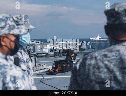 Mitglieder der philippinischen Küstenwache beobachten, wie während eines maritimen Engagements am 31. August 2021 in der Westphilippinischen See ein kleines unbemanntes Flugzeugsystem vom Flugdeck des US-Küstenwachtschneidwerks Munro gestartet wird. Unter der taktischen Kontrolle der 7. US-Flotte führen der Cutter und die Crew einen professionellen Austausch und Übungen zum Aufbau von Kapazitäten mit den Partnerländern durch und patrouillieren und führen Operationen gemäß den Anweisungen durch. Stockfoto