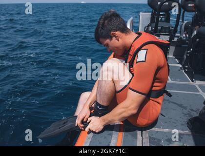 Seaman Jaiden Hartley, ein Rettungsschwimmer an Bord von Coast Guard Cutter Munro, bereitet sich während eines maritimen Engagements am 31. August 2021 mit der philippinischen Küstenwache auf den Eintritt ins Wasser vor. Während der Übung übten die Behörden die Suche nach einem Schiff in Not, Brandbekämpfungstechniken an Bord sowie die Rückgewinnung und Behandlung von Personen im Wasser. Stockfoto