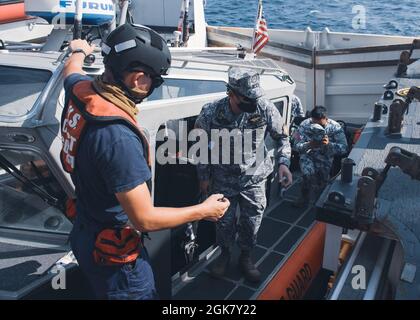 Westley Sellers, ein Partner der US-Küstenwache an Bord von Cutter Munro, begleitet Mitglieder der philippinischen Küstenwache während eines maritimen Engagements am 31. August 2021 in der Westphilippinischen See an Bord von Munro. Mitglieder der Küstenwache an Bord des Munro sind derzeit im Westpazifik stationiert, um Allianzen und Partnerschaften zu stärken und die maritime Governance und Sicherheit in der Region zu verbessern. Stockfoto