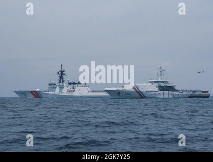 Die US-Küstenwache, Cutter Munro (links) und die philippinische Küstenwache, Offshore-Patrouille Gabriela Silang (rechts), ehren sich nach bilateralen Operationen und Übungen am 31. August 2021 in der Westphilippinischen See. Munro und die Besatzung sind derzeit im Westpazifik stationiert, um Allianzen und Partnerschaften zu stärken und die maritime Governance und Sicherheit in der Region zu verbessern. Stockfoto