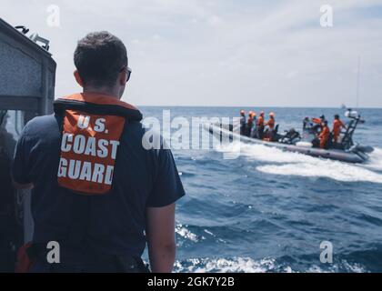 Der Kleinoffizier der US-Küstenwache der 3. Klasse Ethan Dorais, ein Bootsgefährte an Bord von Coast Guard Cutter Munro, sucht während einer Such- und Rettungsübung am 31. August 2021 in der Westphilippinischen See nach einem simulierten Mann über Bord mit Mitgliedern der philippinischen Küstenwache. Die Such- und Rettungsübung simulierte die bilaterale Reaktion beider Agenturen auf ein Schiff in Not. Stockfoto