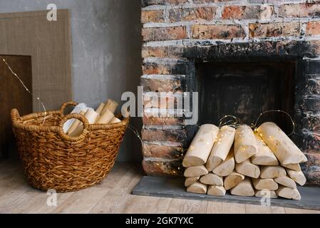 Das Innere eines gemütlichen Steinhauses mit grauen Wänden und einem Kamin mit Baumstämmen Stockfoto