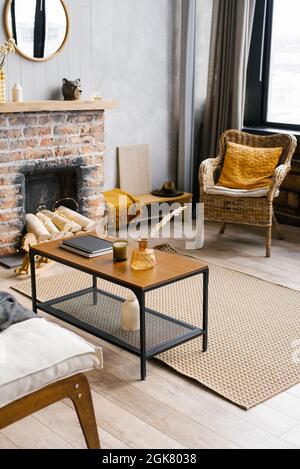 Gemütliches Interieur des Wohnzimmers Rattan Stuhl und Kamin. Rustikales Design des Hauses für einen warmen Innenraum eines Alpenurlaumes. Moderne Einrichtung o Stockfoto