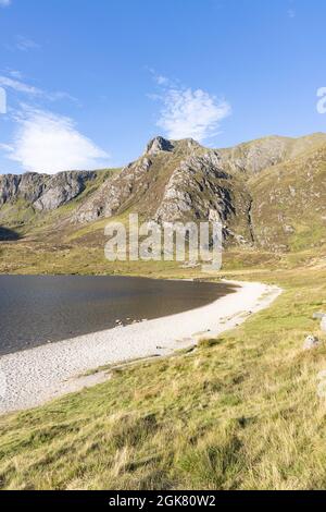 Llyn Idwal, Snowdonia, UK, 8. September 2021: Der leere, weiße Kiesstrand von Llyn Idwal kurvt zu den sich abzeichnenden Klippen von Castell y Geifr. Stockfoto