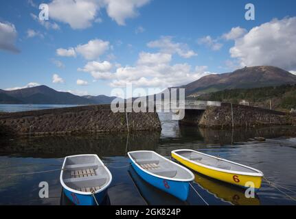 Drei Ruderboote, die am Ufer des Ashi-Sees festgemacht wurden, schauten auf den Berg Fuji, Präfektur Kanagawa, Japan Stockfoto