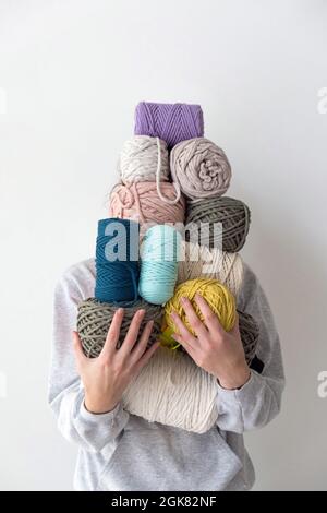 Frau, die Makramgarn-Knäuel in den Händen hält. Kreatives Makramstrickkonzept Stockfoto