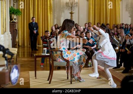 First Lady Michelle Obama umarmt ein Kind, das an der jährlichen Veranstaltung „Take Our Daughters and Sons to Work Day“ im Ostsaal des Weißen Hauses am 22. April 2015 teilnimmt. (Offizielles Foto des Weißen Hauses von Lawrence Jackson) Dieses offizielle Foto des Weißen Hauses wird nur zur Veröffentlichung durch Nachrichtenorganisationen und/oder zum persönlichen Druck durch die Betreffenden des Fotos zur Verfügung gestellt. Das Foto darf in keiner Weise manipuliert werden und darf nicht in kommerziellen oder politischen Materialien, Anzeigen, E-Mails, Produkten oder Werbeaktionen verwendet werden, die in irgendeiner Weise eine Genehmigung oder Billigung o nahelege Stockfoto