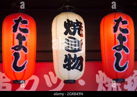 Japanische Laternen, die an einem Fensterrahmen vor dem Geschäft hängen, Osaka, Japan Stockfoto