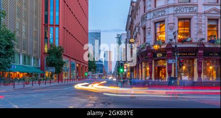 Blick auf die Ampeln und Gebäude von Deansgate in der Abenddämmerung, Manchester, Lancashire, England, Großbritannien, Europa Stockfoto