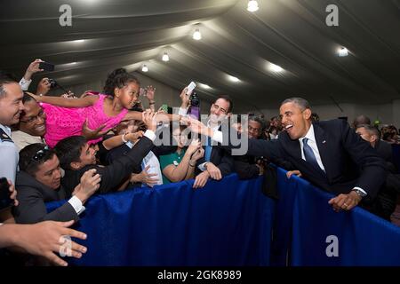 Präsident Barack Obama streckt sich, um einem kleinen Mädchen während eines Botschaftsmeetens die Hand zu schütteln und begrüßt es am 28. April 2014 im Sofitel Philippine Plaza Manila in Manila, Philippinen. (Offizielles Foto des Weißen Hauses von Pete Souza) Dieses offizielle Foto des Weißen Hauses wird nur zur Veröffentlichung durch Nachrichtenorganisationen und/oder zum persönlichen Druck durch die Betreffzeile(en) des Fotos zur Verfügung gestellt. Das Foto darf in keiner Weise manipuliert werden und darf nicht in kommerziellen oder politischen Materialien, Anzeigen, E-Mails, Produkten oder Werbeaktionen verwendet werden, die in irgendeiner Weise eine Genehmigung oder Zustimmung nahelege Stockfoto