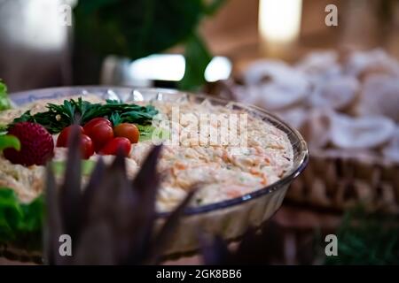 Tigela com salada. Alface, Tomate, azitonas e molho. Grande variedade de comida organizada em mesa de Buffet festiva. Stockfoto