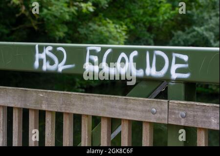 Denham, Buckinghamshire, Großbritannien. September 2021. HS2 Ökozid-Graffiti auf einer Brücke über den Fluss Colne im Denham Country Park.die Hochgeschwindigkeitsstrecke von London nach Birmingham gefährdet 693 Wildtierstätten, 108 uralte Waldgebiete und 33 SSSIs. Quelle: Maureen McLean/Alamy Stockfoto