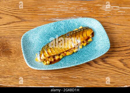 Marinierte Makrele auf blauem Teller mit Mangosalat. Stockfoto