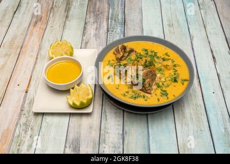Graue Schale aus ecuadorianischer grüner Kugelbrühe auf Holztisch Stockfoto