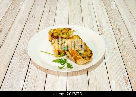 Eintopf mit Schnecken, Kartoffeln und Pilzen, gerollt mit einer Weizentortilla und auf dem Grill zubereitet Stockfoto