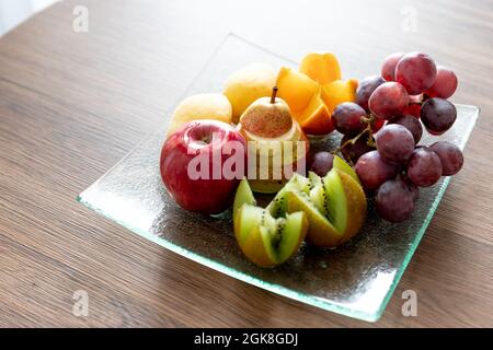 Frisches Mischobst auf Teller.leckere Früchte.Obstschale als gesundes Essen für Party- und Feiertags-Tisch. Stockfoto