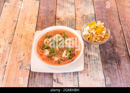 Shrimp Ceviche mariniert mit viel Koriander, Garnelen, Flüssigkeit und als Garnierung eine Schüssel Gericht, alles auf einem Holztisch Stockfoto