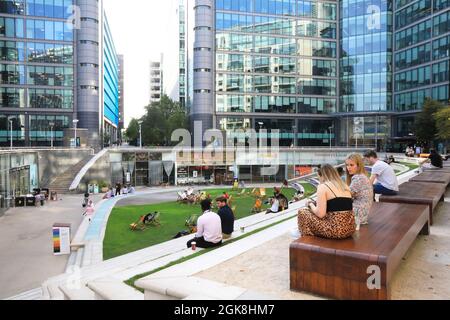Arbeiter, die an einem warmen, sonnigen Nachmittag in Paddington Central, West London, in den Unternehmensbüros des Sheldon Square sitzen, VEREINIGTES KÖNIGREICH Stockfoto