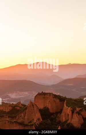 Malerischer Blick auf herrliche Berge mit Moos und Bäumen unter hellem Himmel bei Sonnenuntergang Stockfoto