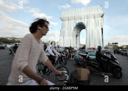 Paris, Frankreich. September 2021. Pendler fahren am Montag, den 30. September 2021, um den Arc de Triomphe, der in silberblauem Stoff gewickelt wird. Das Wahrzeichen ist mit 25,000 Quadratmetern Material bedeckt und erfüllt posthum einen 60-jährigen Traum für den Künstler Christo. Foto von Eco Clement/UPI Credit: UPI/Alamy Live News Stockfoto