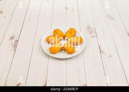 Portion frisch zubereiteter iberischer Schinkenkroketten auf schwarzem Hintergrund Stockfoto