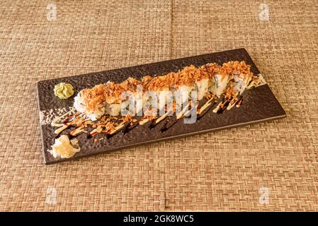 Uramaki Drachenrolle mit knuspriger Zwiebel gefüllt mit Surimi mit Wasabi und Ginseng Stockfoto