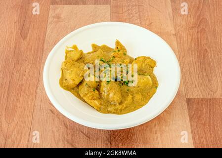 Rezept für das verkoste Huhn mit geriebenem Kokosnuss und Schnittlauch auf einem Holztisch Stockfoto