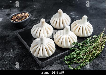 Rohe Knödel Krinkali mit Rind- und Lammfleisch. Schwarzer Hintergrund. Draufsicht Stockfoto