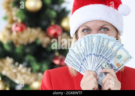 Porträt einer Frau im weihnachtsmannhut mit Fan mit Bargeld amerikanischen Dollar Stockfoto