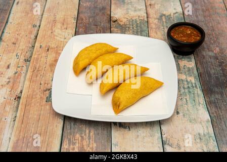 Ration von kolumbianischen Maismehl Empanadas gefüllt mit Fleisch und Sauce zum Eintauchen Stockfoto