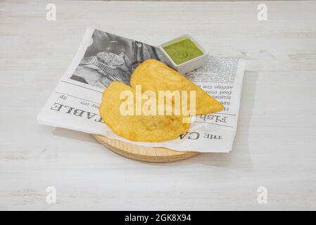 Kolumbianische Maismehl-Empanadas mit Dip-Sauce auf Holzplatte Stockfoto