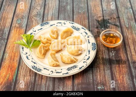 Teller mit asiatischen gekochten Gyoza mit süßer und saurer Sauce serviert Stockfoto