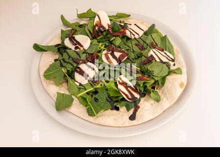 Ziegenkäse-Salat mit Spinat, dehydrierten Tomaten und modena-Essig auf einem Weizenbrot-Omelett Stockfoto