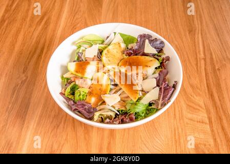 Sprout-Salatschüssel mit Apfelscheiben, weißen Zwiebeln, Thunfisch-Torozos aus der Dose und Parmesan-Käseflocken Stockfoto