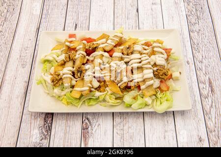 Teller Caesar-Salat mit zerschlackenem Huhn, Salat, Walnüssen, Croutons und Mayonnaise-Sauce Stockfoto