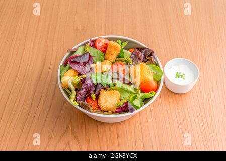 Gemischter Salat aus Rosensalat, Chicken Nuggets, grüner Spargel, Kirschtomaten und Mayonnaise-Sauce Stockfoto