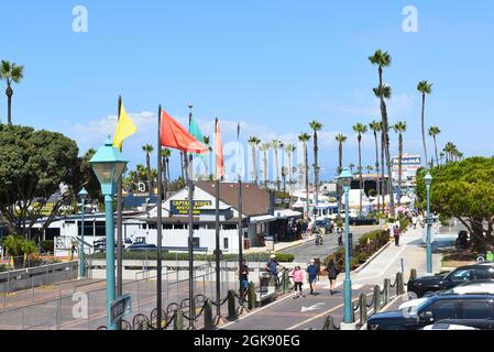 REDONDO BEACH, CALIFORNIA - 10 SEP 2021: Die Menschen schlendern auf der Promenade in der Marina vorbei an Geschäften und Restaurants, Stockfoto