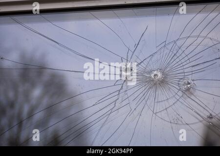 Einschusslöcher in einer Glasscheibe Stockfoto