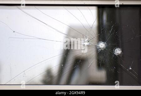 Einschusslöcher in einer Glasscheibe Stockfoto