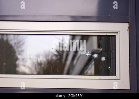 Einschusslöcher in einer Glasscheibe Stockfoto