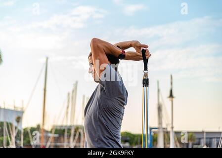 Junger lateinischer Mann, der mit Gummibeinen im Freien Sport macht Stockfoto