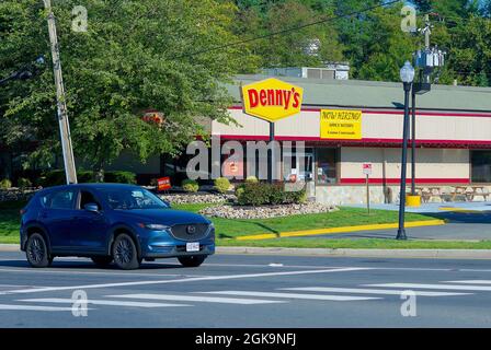 Fairfax, Virginia, USA - 3. September 2021: Ein Auto fährt an einem Denny's Restaurant vorbei und hat ein Schild mit der Aufschrift „Jetzt einstellen“, auf dem neue Mitarbeiter gesucht werden, um freie Stellen zu besetzen. Stockfoto