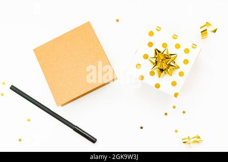 Draufsicht auf goldgepunktete Geschenkschachteln und leere Karte auf weißem Hintergrund. Platz kopieren, Modell. Stockfoto