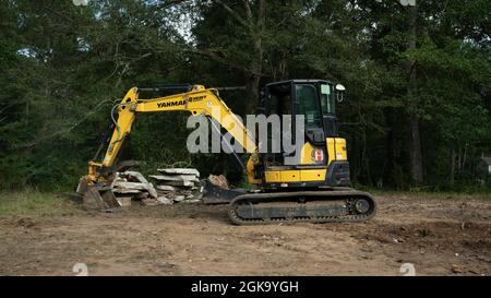 Yellow yanmar Bagger Abriss alten Ziegelkamin viel zu löschen Stockfoto